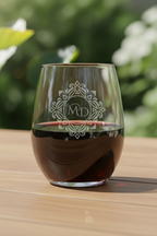 Glass of dark liquid with a logo on a wooden surface with a blurred green background