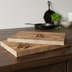 Two wooden cutting boards with engraved designs on a wooden surface.