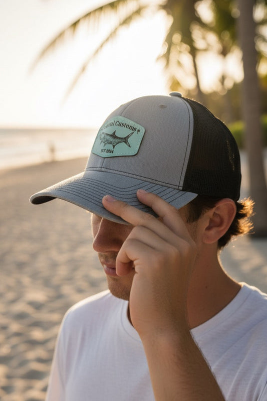 Person wearing a cap with a logo on a beach